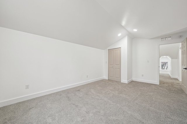 bonus room with arched walkways, light colored carpet, visible vents, vaulted ceiling, and baseboards