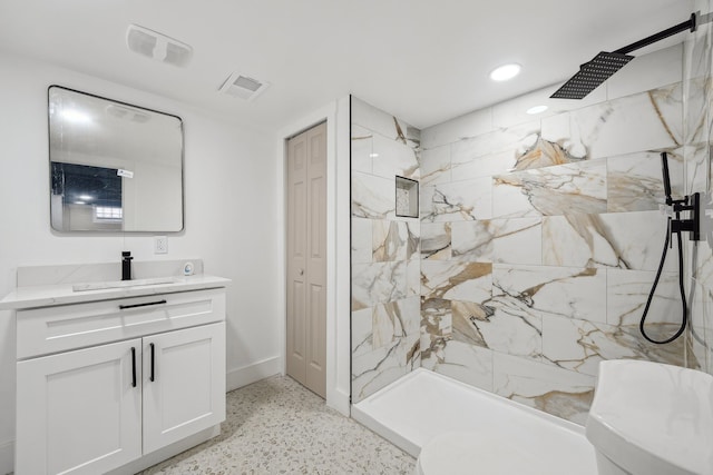 bathroom featuring visible vents, speckled floor, a marble finish shower, and vanity