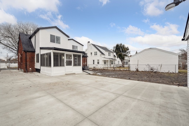 back of property with a sunroom, fence, cooling unit, and a patio