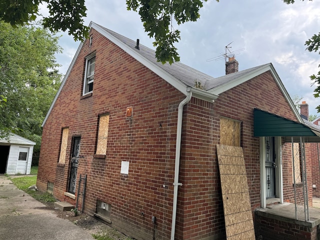 view of property exterior with brick siding and a chimney