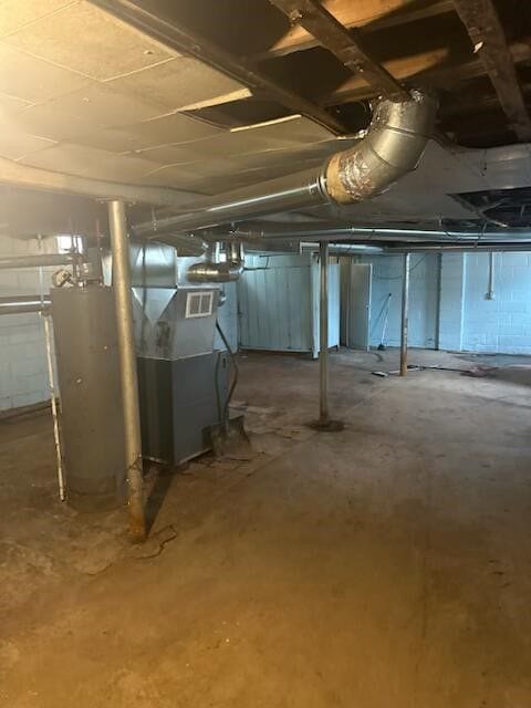 unfinished below grade area featuring water heater and visible vents