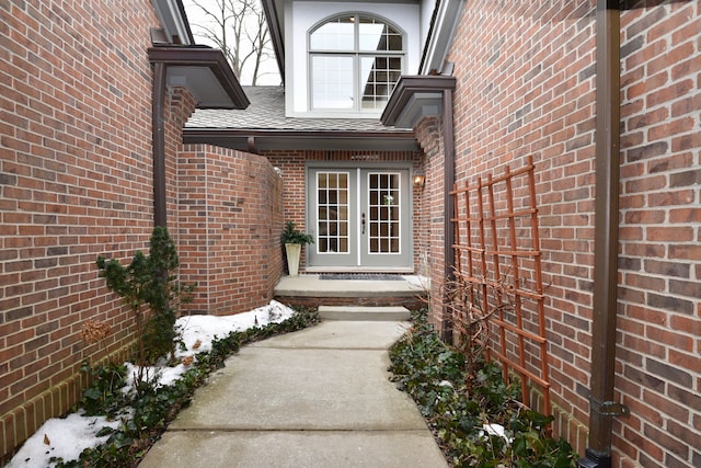 property entrance featuring brick siding, roof with shingles, and french doors