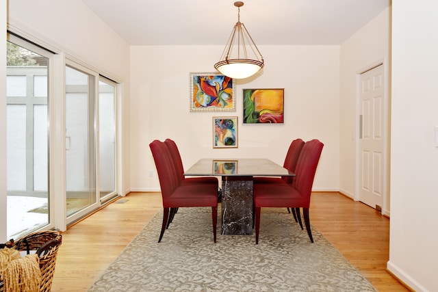 dining space featuring light wood finished floors and baseboards