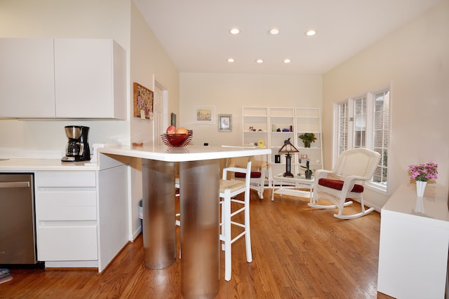 kitchen featuring light wood-type flooring, white cabinetry, light countertops, and dishwasher