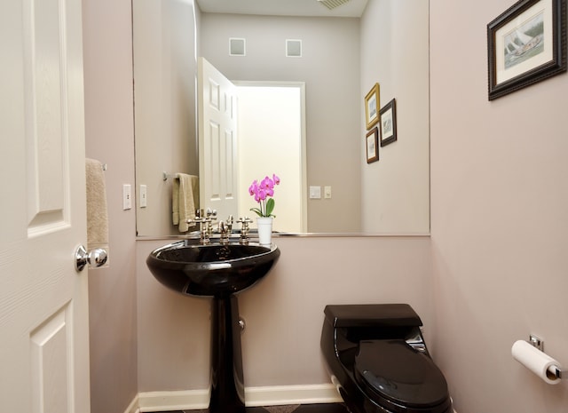 bathroom with visible vents, a sink, and toilet