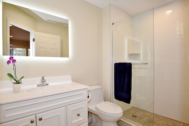 full bathroom with vanity, walk in shower, and toilet