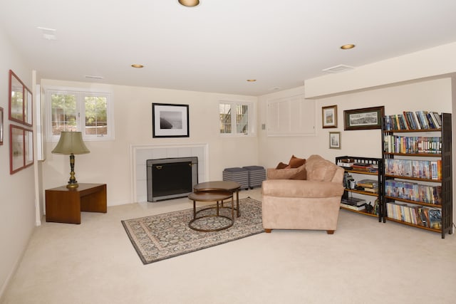 carpeted living room featuring a tiled fireplace, visible vents, and recessed lighting