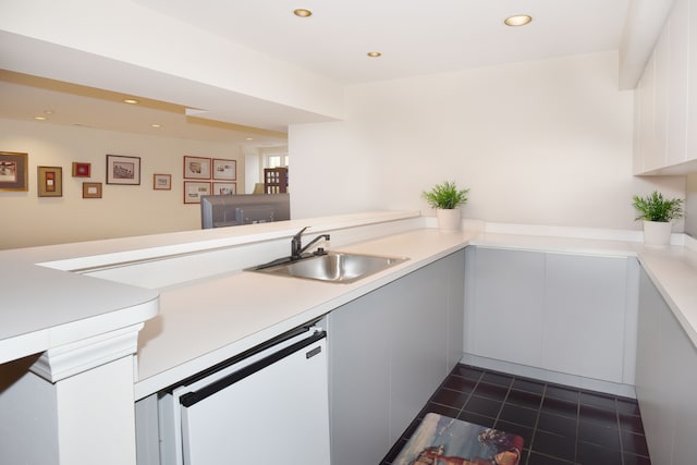 kitchen featuring a peninsula, light countertops, a sink, and recessed lighting