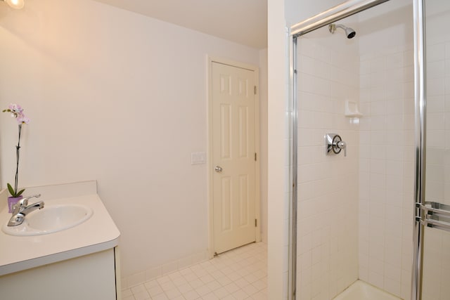 full bathroom featuring tile patterned flooring, baseboards, tiled shower, and vanity