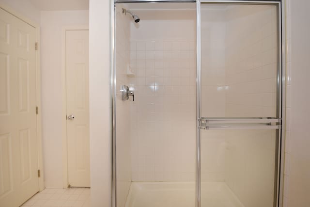 bathroom with tile patterned flooring and a shower stall