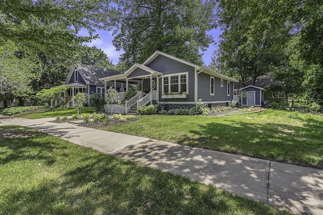 view of front of home featuring covered porch, a front lawn, an outdoor structure, and a storage unit