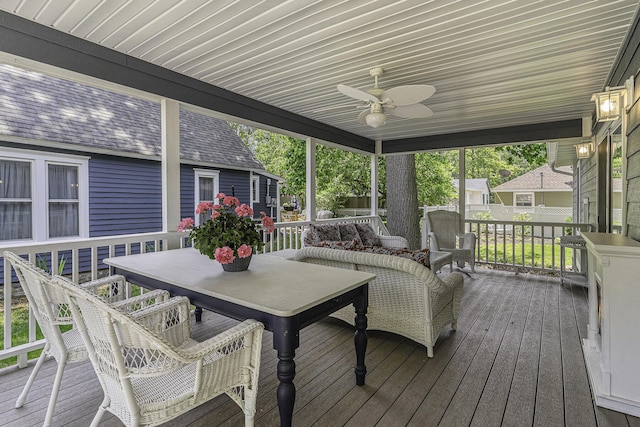 wooden deck with outdoor dining area and a ceiling fan