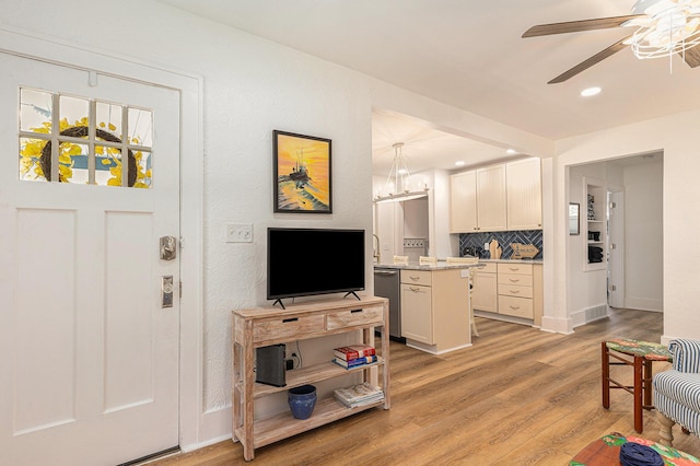 living area featuring light wood finished floors, ceiling fan, baseboards, and recessed lighting