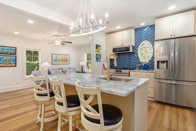 kitchen with stainless steel appliances, light wood finished floors, and a wealth of natural light