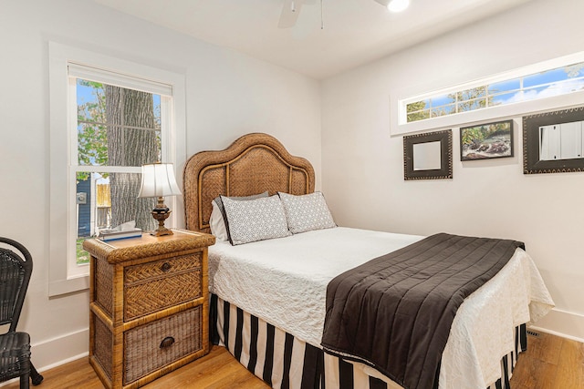 bedroom with a ceiling fan, baseboards, and wood finished floors