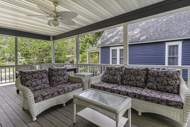 wooden terrace with an outdoor hangout area, outdoor dining space, and a ceiling fan