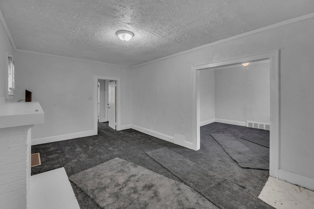 interior space with a textured ceiling, carpet flooring, visible vents, baseboards, and crown molding