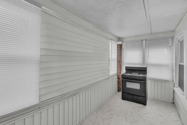 kitchen featuring marble finish floor and black range oven