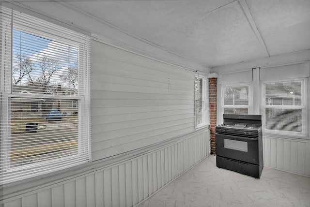 kitchen featuring marble finish floor, a wealth of natural light, and black range