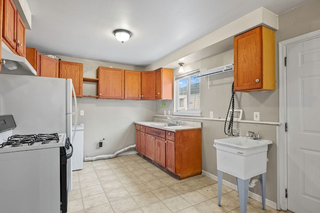 kitchen featuring under cabinet range hood, a sink, brown cabinetry, open shelves, and gas range oven