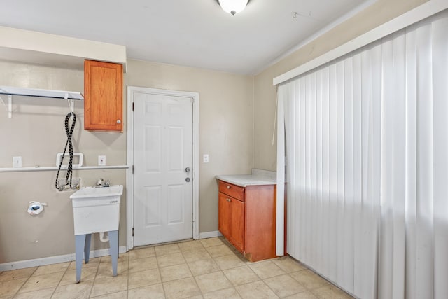 kitchen with light countertops, brown cabinetry, and baseboards