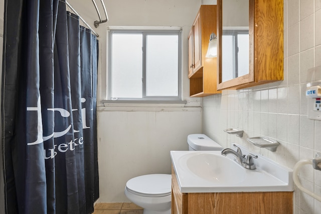 bathroom with curtained shower, vanity, toilet, and tile walls