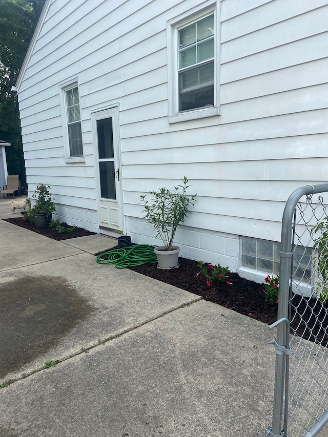 doorway to property with a patio, fence, and a gate