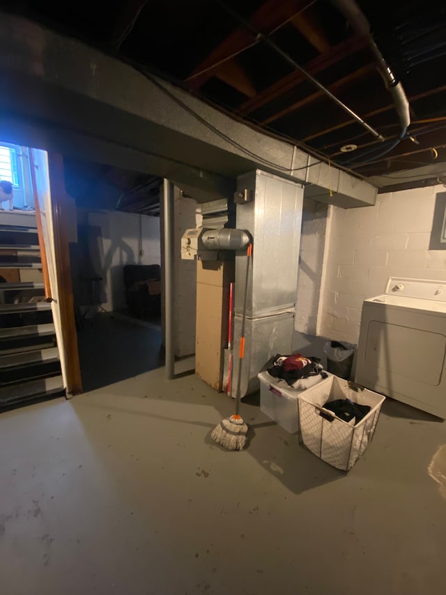 unfinished below grade area with stairs, washer / dryer, and heating unit