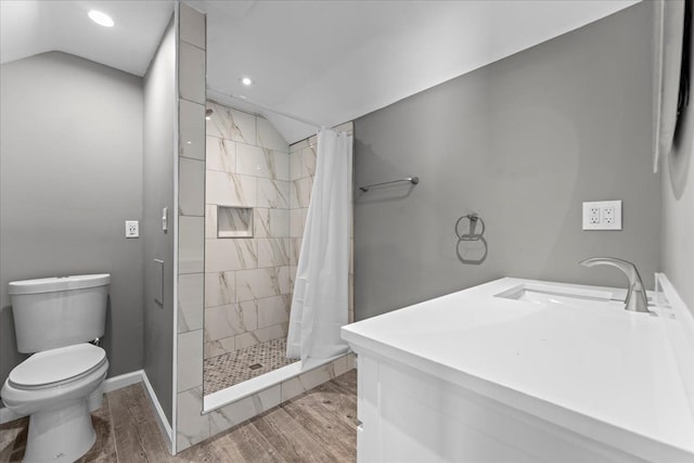 bathroom featuring vaulted ceiling, toilet, wood finished floors, and a stall shower