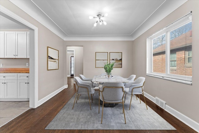 dining area featuring visible vents, baseboards, and dark wood-type flooring