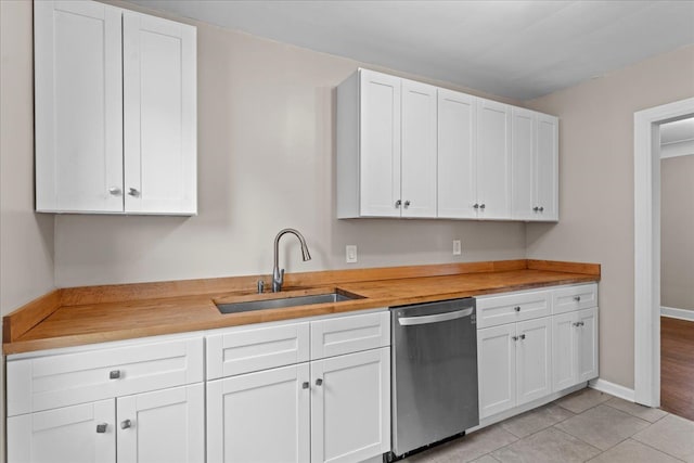 kitchen featuring white cabinets, dishwasher, butcher block counters, and a sink