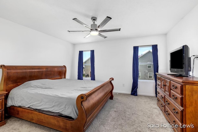 bedroom featuring light carpet, ceiling fan, and baseboards