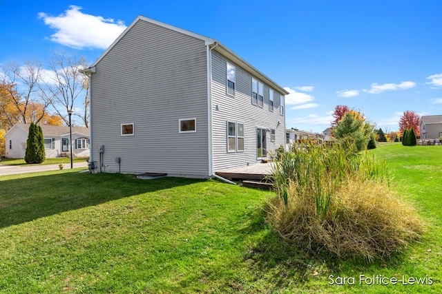 view of property exterior with a deck and a yard