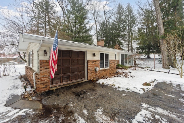 view of front of home with a chimney and brick siding