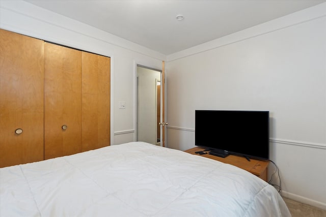 bedroom with a closet, carpet, and baseboards