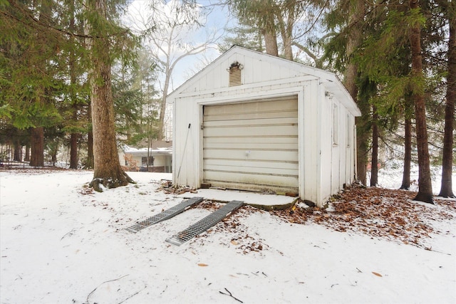 snow covered garage with a detached garage