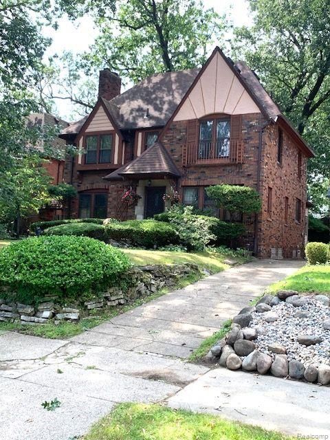 tudor house with brick siding and a chimney