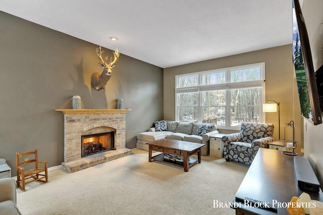 carpeted living area featuring a fireplace and baseboards