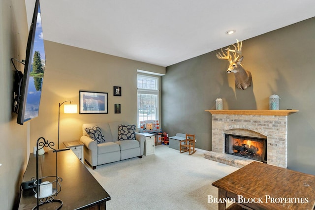 living area with carpet floors and a brick fireplace