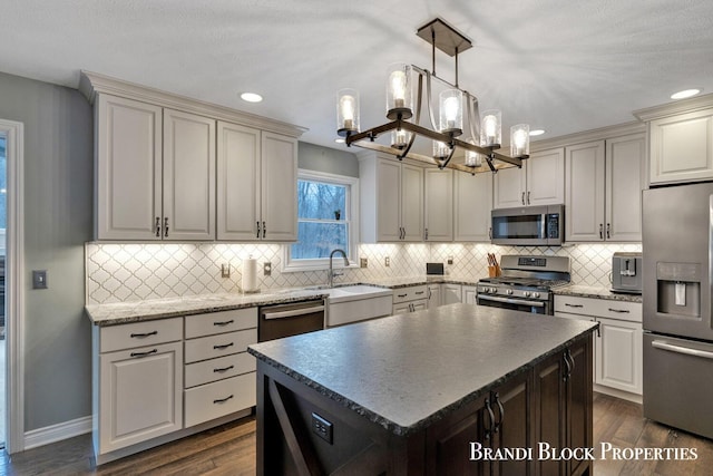 kitchen with stainless steel appliances, dark wood-style flooring, a sink, a center island, and decorative backsplash