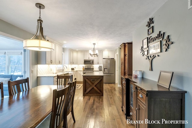 dining space with a textured ceiling, hardwood / wood-style floors, and visible vents