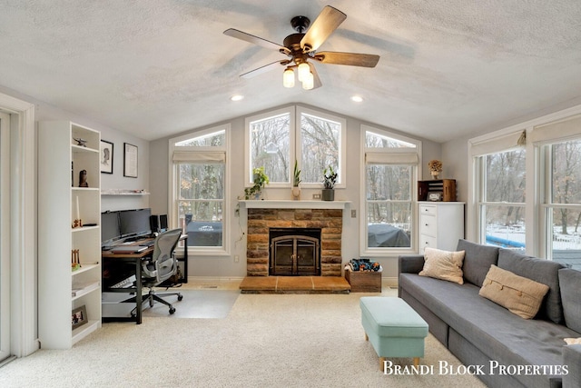 office featuring lofted ceiling, plenty of natural light, a stone fireplace, and a textured ceiling