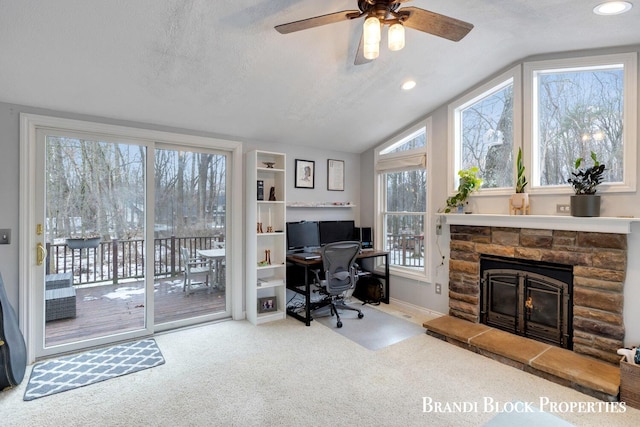 office space with a textured ceiling, a fireplace, carpet flooring, and lofted ceiling