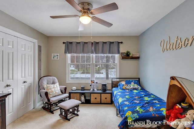 carpeted bedroom with ceiling fan and a closet