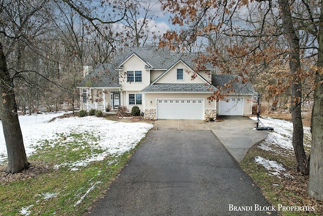 traditional-style house featuring stone siding and driveway