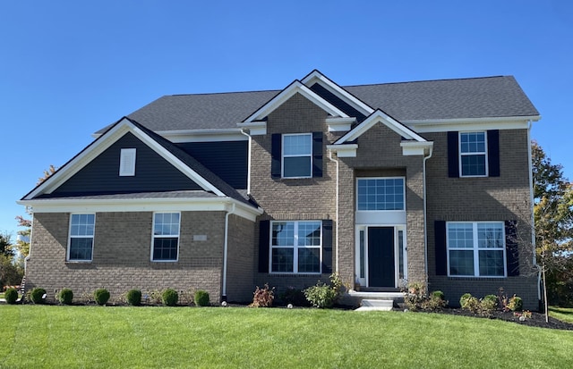 craftsman house with brick siding and a front yard