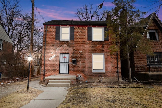 view of front of house featuring brick siding and fence