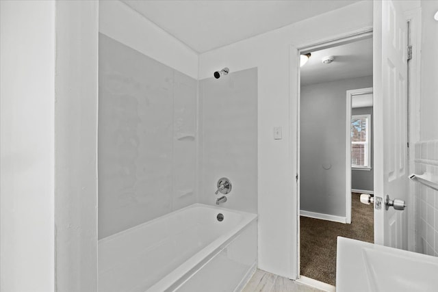 bathroom featuring baseboards and shower / bathing tub combination