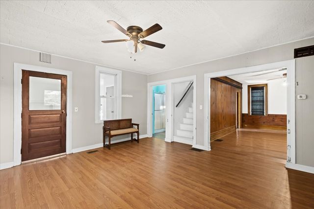 entrance foyer featuring ceiling fan, stairs, visible vents, and wood finished floors