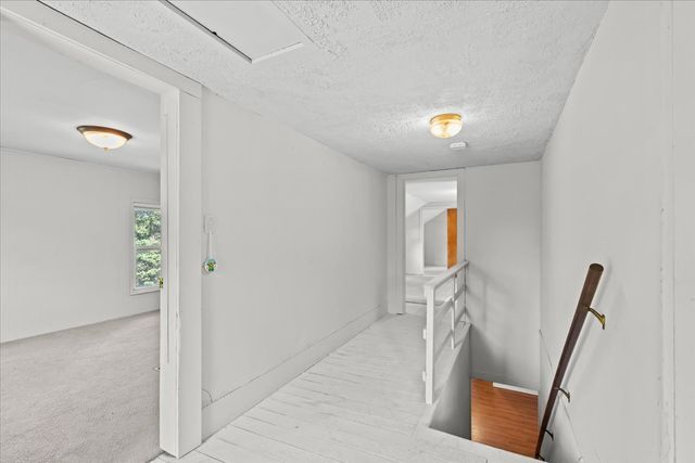 hallway featuring a textured ceiling and an upstairs landing